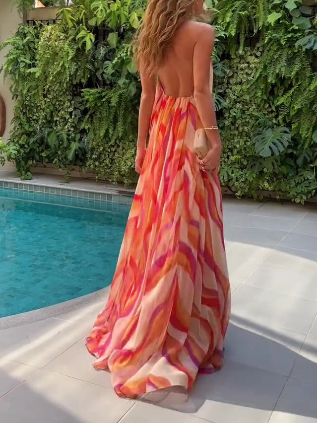Woman in a colorful dress standing by a pool with greenery in the background
